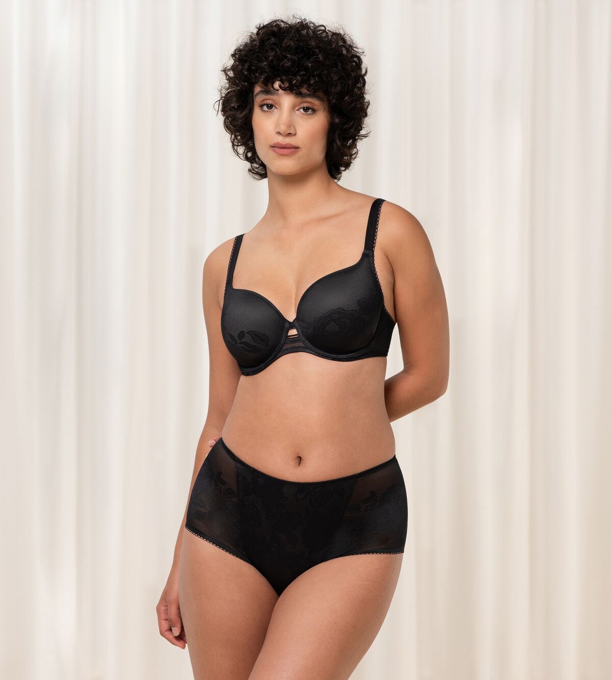 Triumph Wild Rose Sensation black padded wired bra third model full front view, featuring floral lace detailing. Find Online Now.