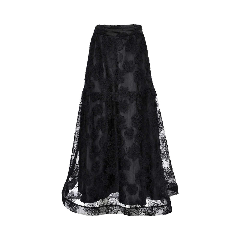 Front view of a TUBA ERGIN black maxi skirt featuring 3D floral lace appliqués and a sheer tiered hem on a white background.
