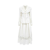 Front view of a women's luxury off-white two-piece set by Tuba Ergin, featuring a structured tailored blazer with gold hardware and a pleated maxi skirt, both finished with sheer panels and intricate white guipure lace detailing.