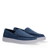 Pair of blue Calvin Klein Kids slip-on sneakers with white platform soles and moccasin stitching.