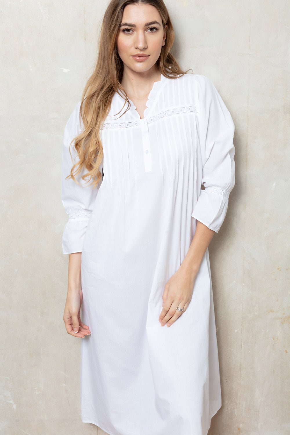 White nightdress with a ruffled stand collar, partial button placket, pintucked bodice, lace trim, and long poet sleeves with