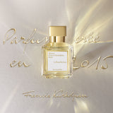 Rectangular clear glass perfume bottle with light yellow liquid, a gold-toned rectangular cap, and a white label.