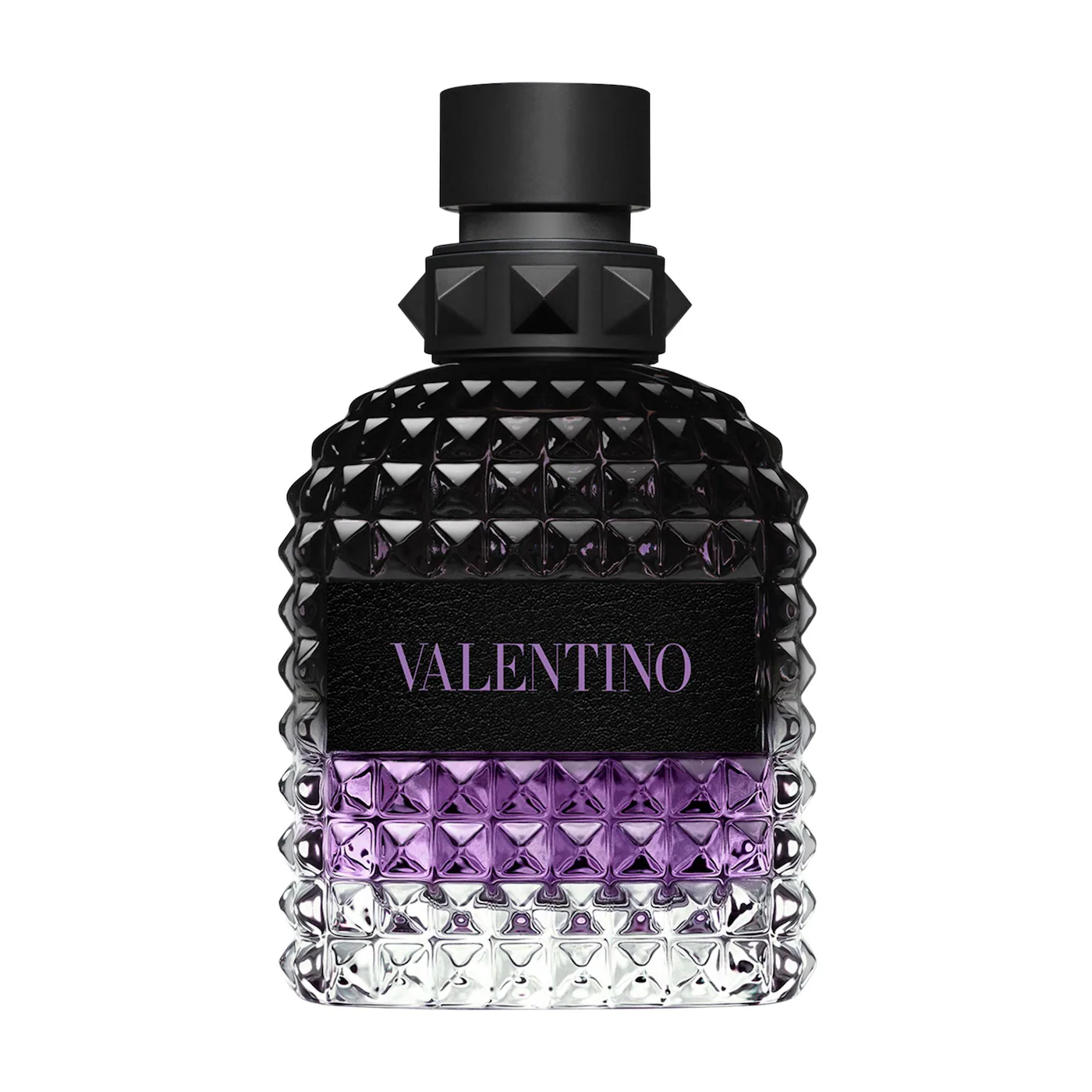 A close-up of a Valentino Uomo Born In Roma Stravaganza fragrance bottle. The glass features the signature rockstud pyramid texture with a gradient transitioning from clear at the base to a vibrant purple in the middle and a deep, translucent black at the top. It is finished with a matte black cap and a black leather-style label with purple branding.
