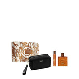 Versace Eros Najim pour homme gift set featuring a bronze and white baroque patterned box, a black zippered pouch with a wristlet strap, a travel spray, and the signature amber-toned maze textured perfume flacon.
