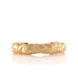 Gold-toned wavy cuff bangle with handset clear stones in elongated oval patterns.