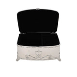 The interior of an ornate silver jewelry box showing black velvet lining and a divided section for rings and accessories.