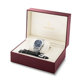 The open burgundy Aigner gift box displaying the Diano AGT251002 watch with a blue dial resting on a cream cushion, alongside the interchangeable black leather strap.