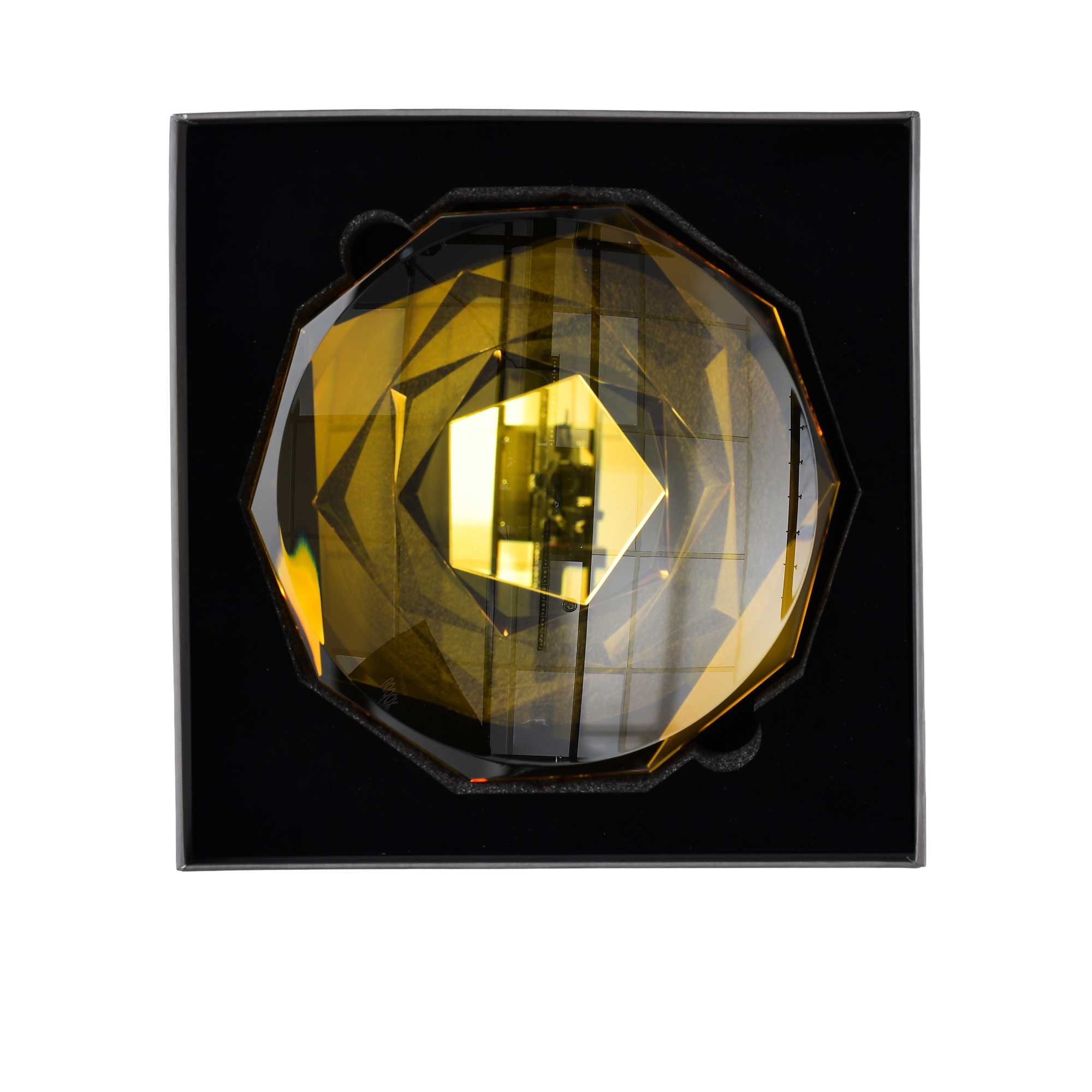 Decorative wall light with geometric design on a black background.