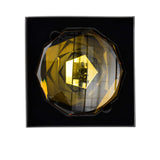 Decorative wall light with geometric design on a black background.