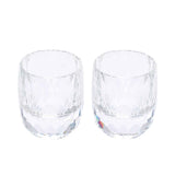 A pair of clear crystalline shot glasses with a decorative diamond-cut pattern on the base and vertical ridges.