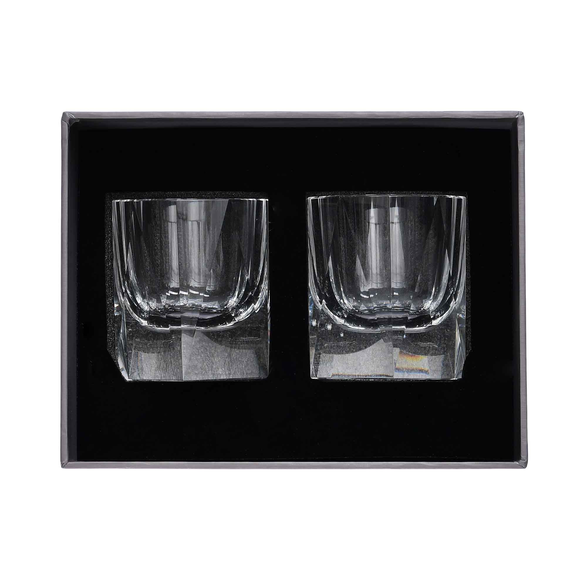 A luxury grey textured gift box containing two crystal whiskey glasses securely held in a black foam compartment.