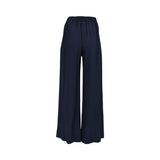 Back view of the Momonì navy blue wide-leg trousers, highlighting a gathered elasticated waistband and the relaxed, floor-length flow of the lightweight fabric.