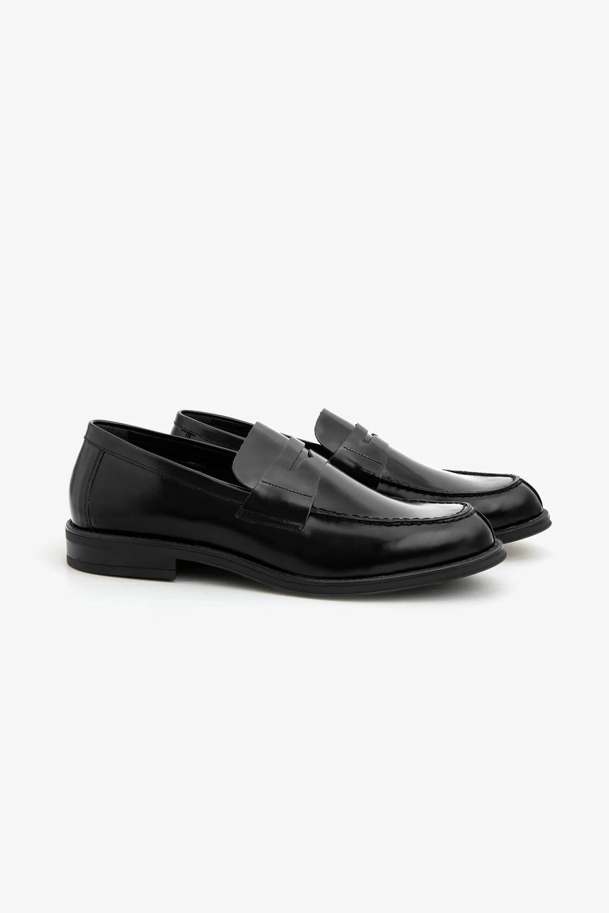 Black polished leather penny loafers with a strap across the vamp and visible stitching around the toe box.