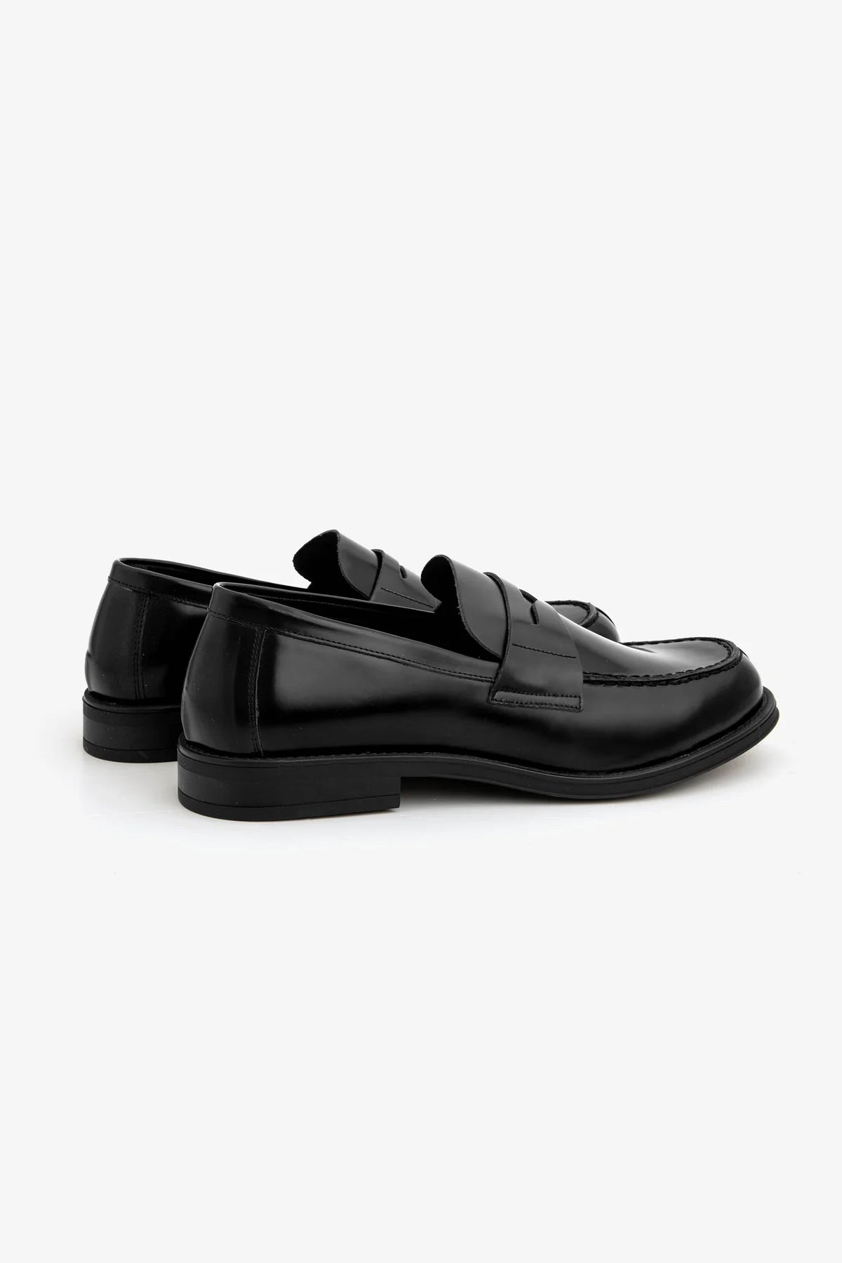 Two black polished leather penny loafers with classic vamp straps and visible stitching around the toe box.