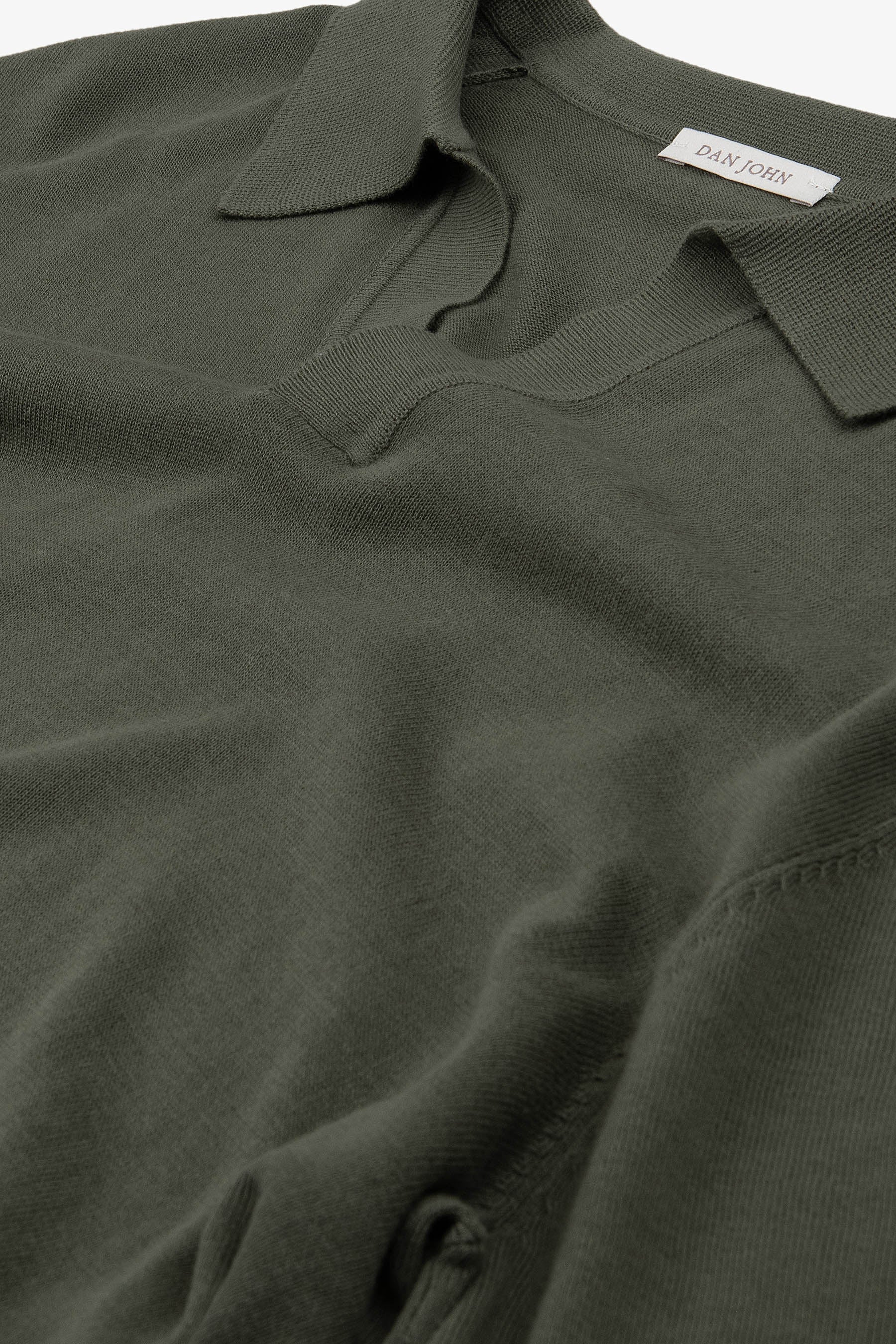 Dark green fine-knit top with a polo collar and a V-neck opening. The soft knit fabric shows subtle texture.