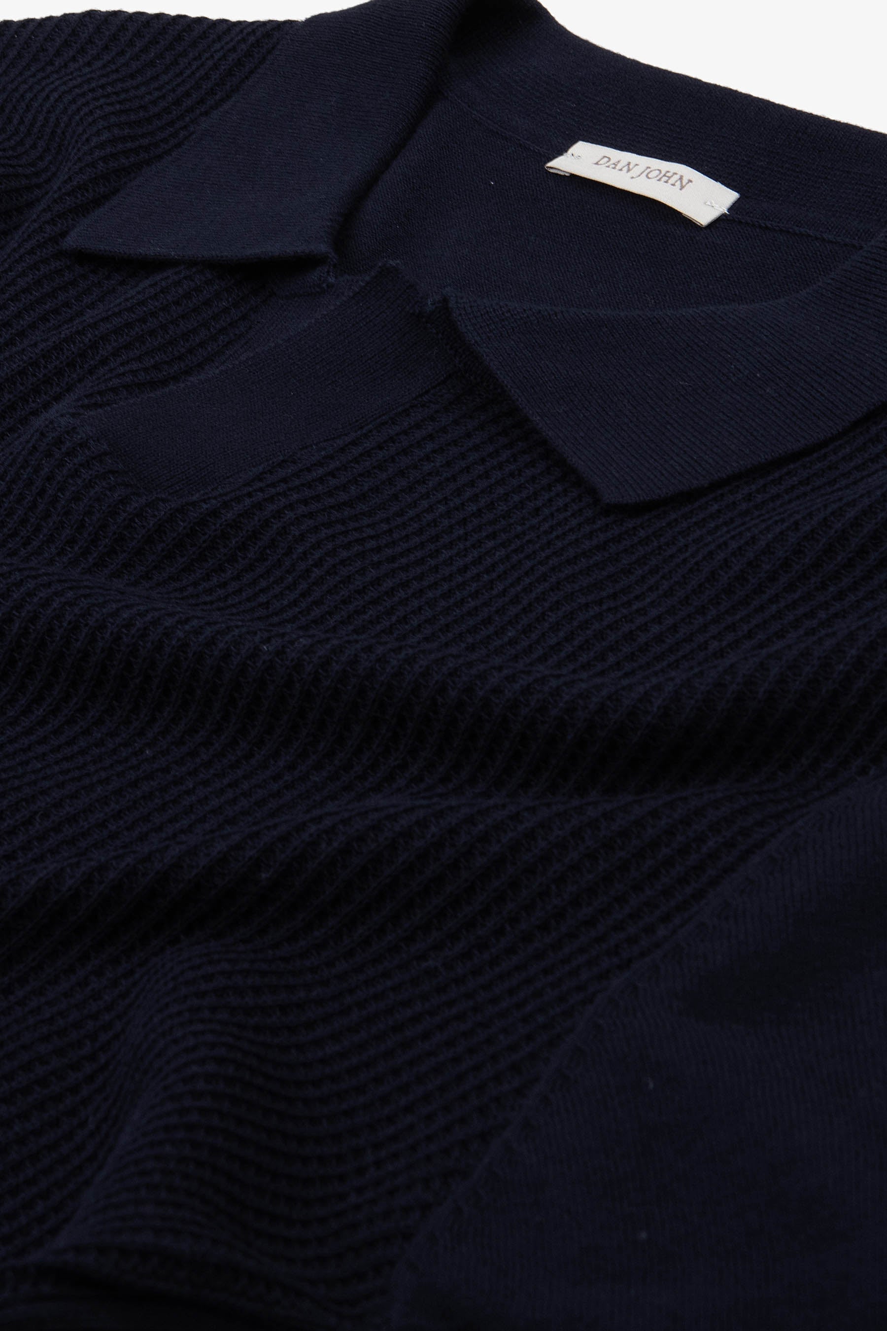 Dark blue short-sleeve knit polo shirt with a ribbed texture body, smooth collar, and V-neck opening.
