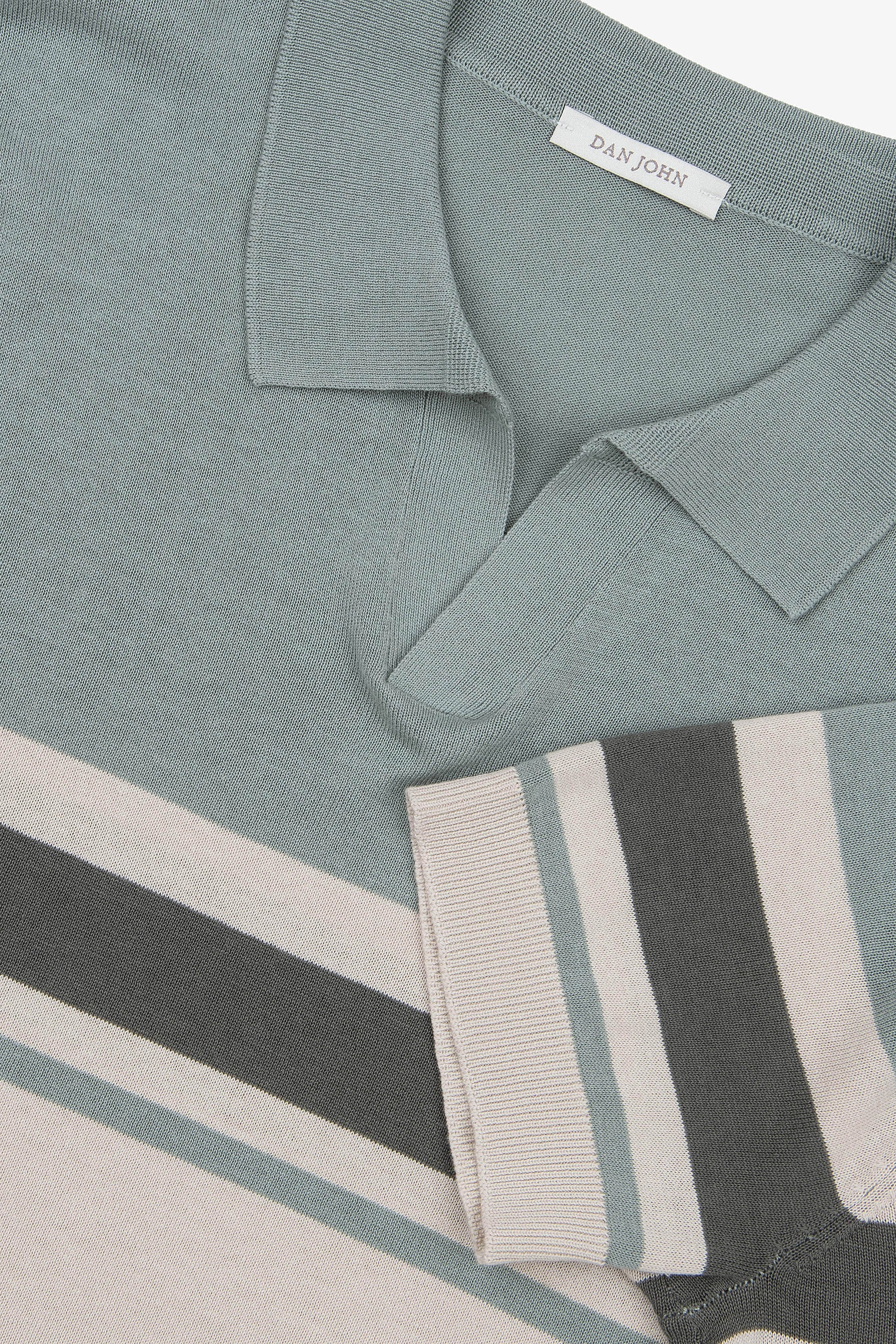 Light green knit polo with collar, short ribbed sleeves, and diagonal/vertical stripes in light green, dark green, off-white.