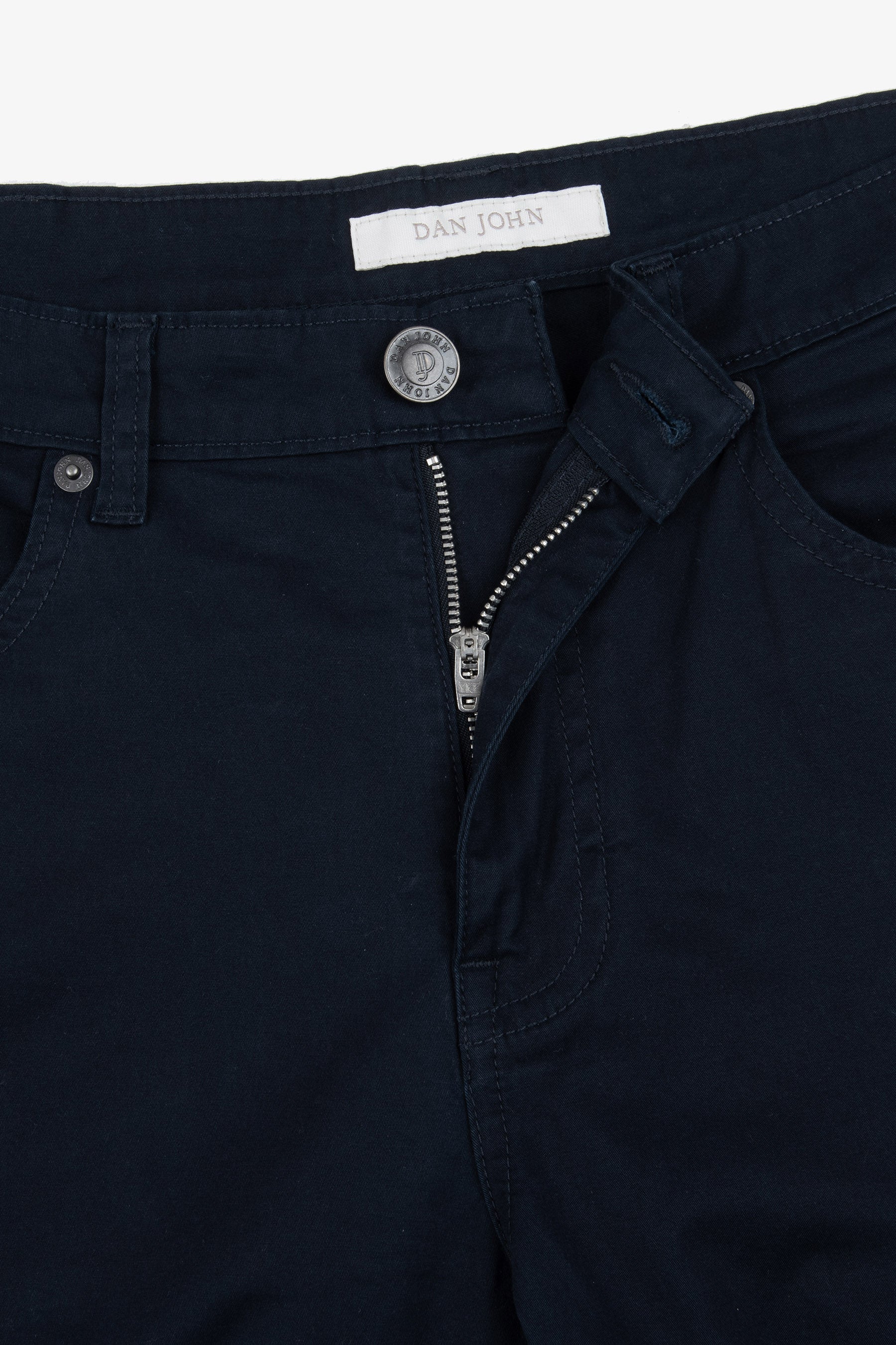 Navy blue trousers with a silver-toned button, unzipped silver-toned zipper, belt loops, and front pockets with rivets. "DAN