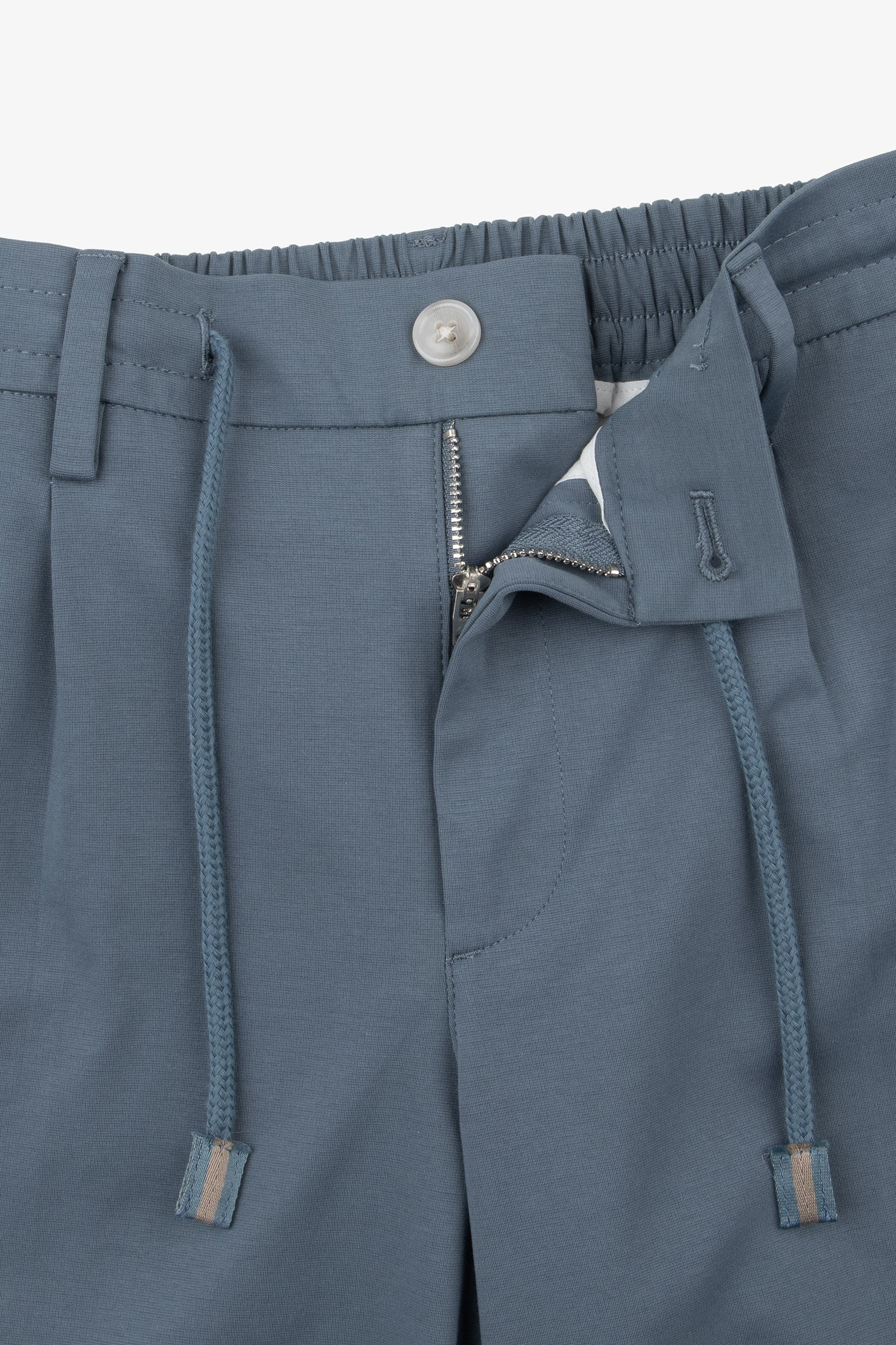 Blue-grey woven trousers with an elasticated back waist, front zipper, light grey button, and blue-grey drawstrings with stri