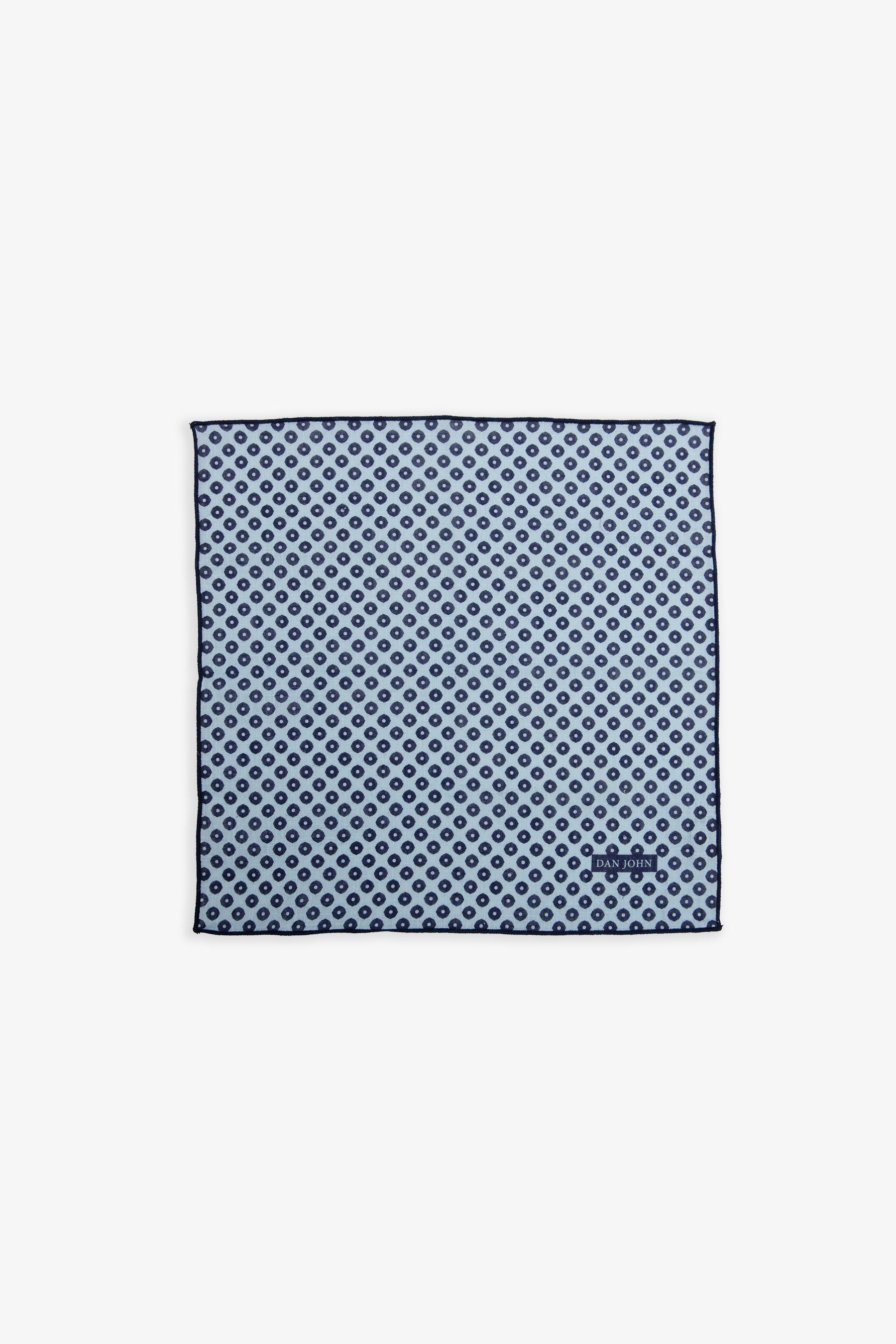 Light blue square handkerchief with a repeating pattern of dark blue dots and a dark blue border, featuring a small 'DAN JOHN
