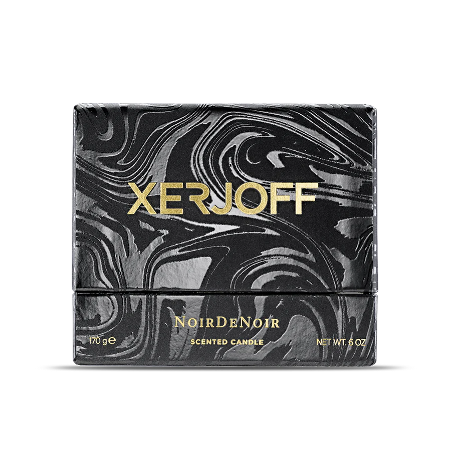 The Noir De Noir scented candle displayed inside its open luxury gift box, featuring a black glass holder decorated with a gold geometric star design and the Xerjoff emblem.