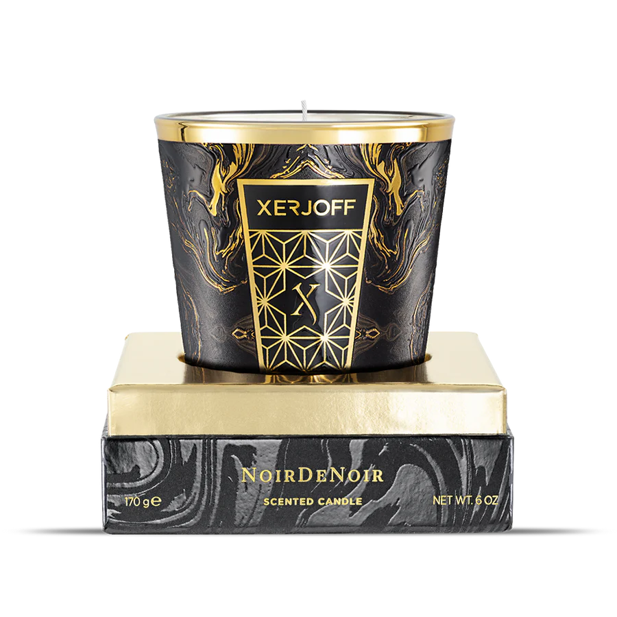 The luxury packaging for the Xerjoff Noir De Noir candle, showcasing a dark grey and white marble-patterned box with a prominent gold "X" logo and gold-stamped product name.