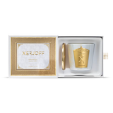 An iridescent white glass candle holder with a large decorative gold crest, shown next to a gold lid embossed with the Xerjoff brand name.