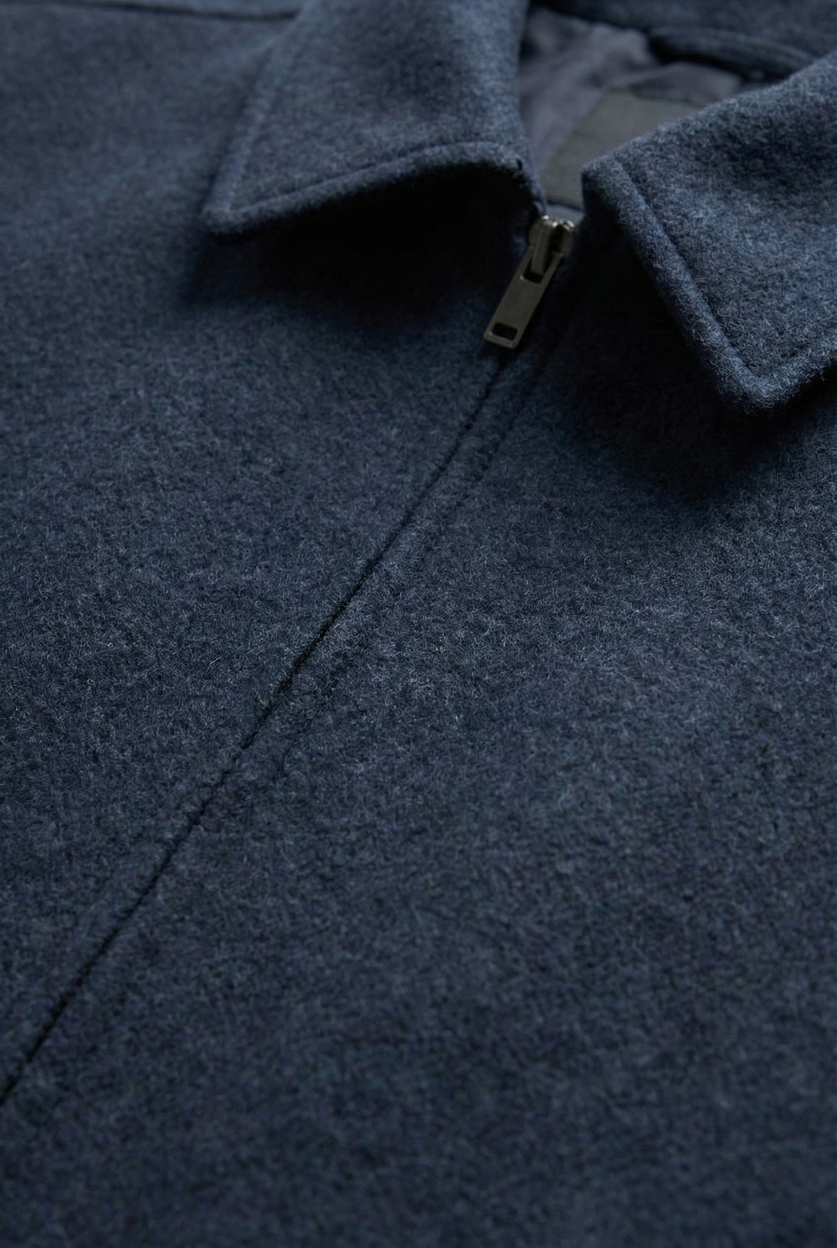 Dark blue felted jacket with a folded collar, a vertical front seam, and a silver-toned zipper closure.