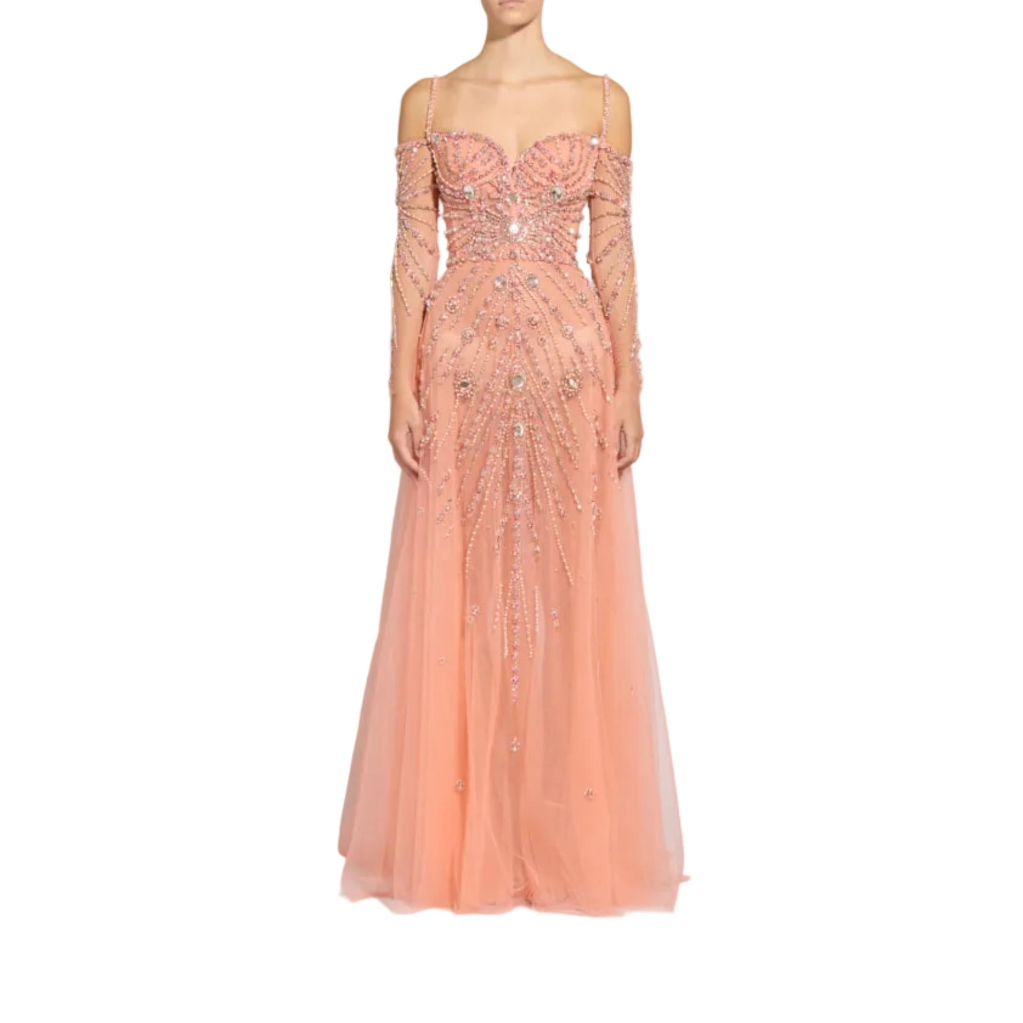 A peach pink off-the-shoulder tulle evening gown with long sheer sleeves and intricate silver beadwork, shown on a headless mannequin against a plain white background.