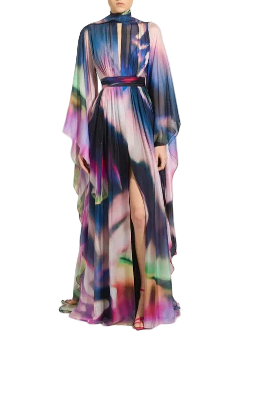 A high-neck, long-sleeved maxi dress with a colorful abstract watercolor print, featuring a matching waist belt and a thigh-high slit, shown on a model against a white background.
