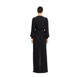 Rear view studio shot of a model highlighting the clean, fluid draping, gathered shoulders, and sleek hair bun of the black Zuhair Murad long-sleeve evening gown, from the BLUE SALON.