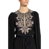 Close-up studio portrait focusing on the opulent hand-applied crystal, bead, and pink rhinestone baroque bib embroidery around the keyhole neckline of the black Zuhair Murad gown.