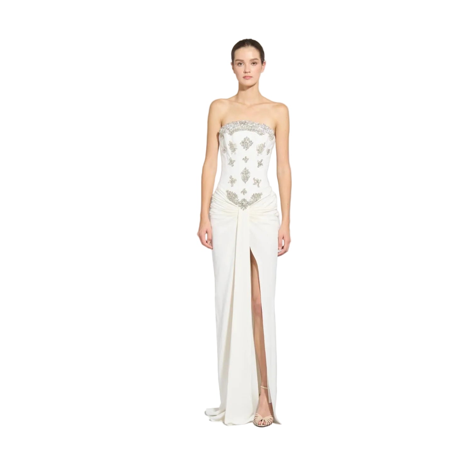 Front studio portrait of a model showcasing a strapless off-white Zuhair Murad evening gown featuring intricate silver crystal bodice embellishments and a draped front-slit skirt.