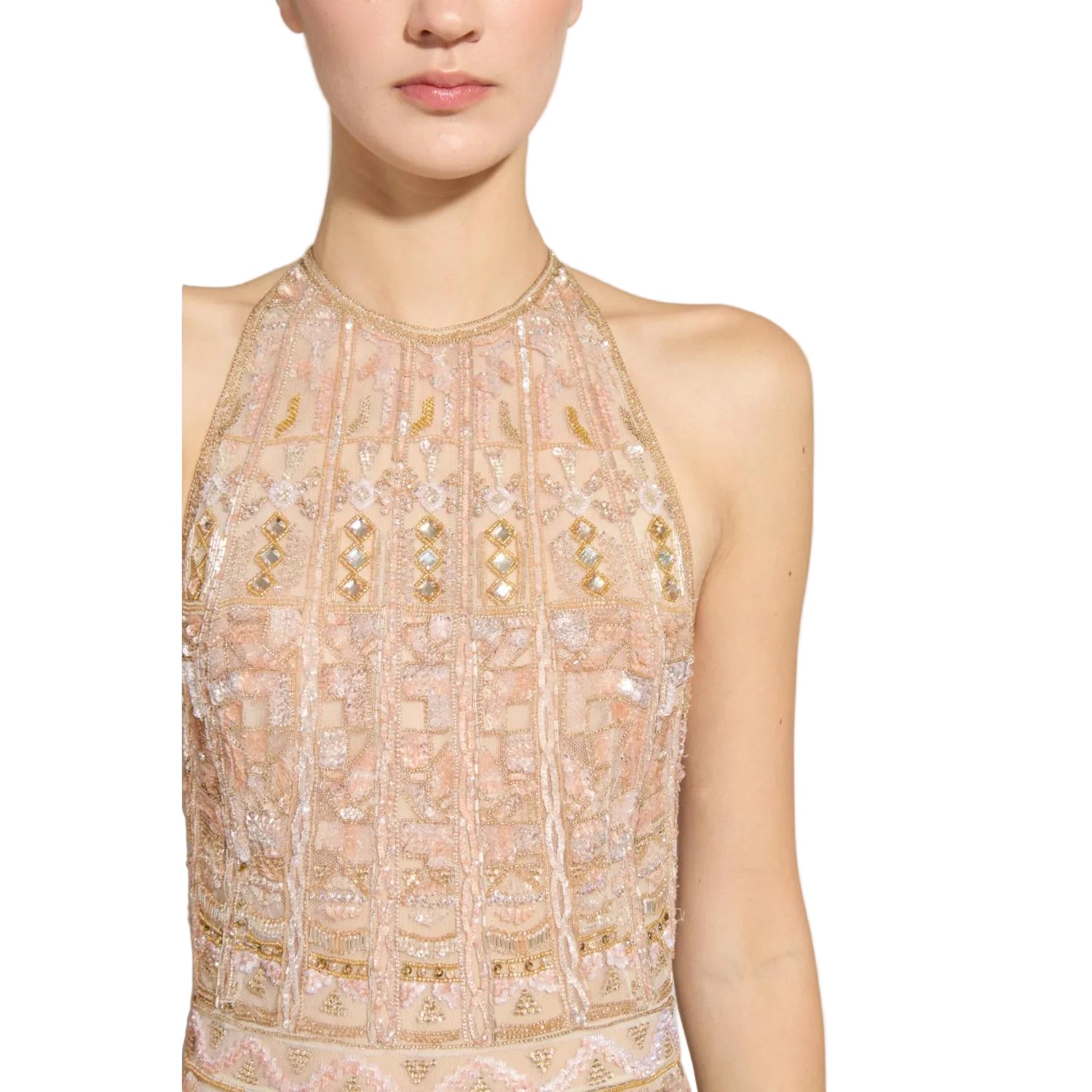 Close-up of a person wearing a beige beaded top on a plain background.