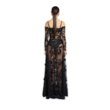 Rear view studio shot of a model showing the back details, long sleek ponytail, and center zip closure of the sheer black Zuhair Murad floral lace gown, available at the BLUE SALON shop.