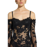 Black lace dress with long sleeves on a neutral background.