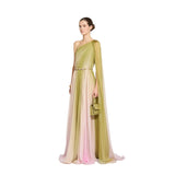 Three-quarter length studio presentation of a model wearing the Zuhair Murad one-shoulder olive multi-gradient chiffon gown while holding a structured sage green mini handbag.