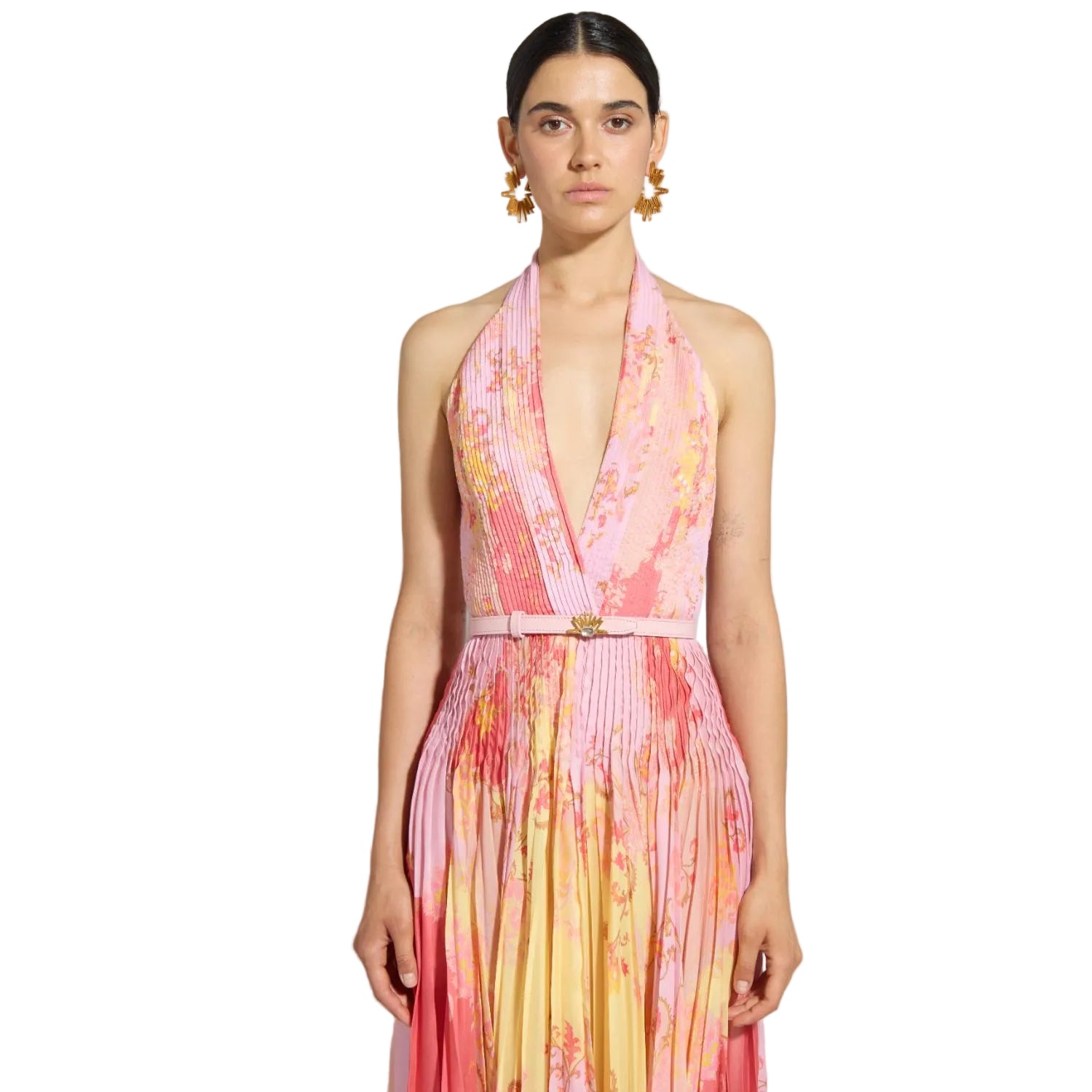 Woman wearing a colorful dress with a plain background.