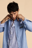 Optic white button-down shirt made of light fabric, featuring thin blue vertical stripes, a collar, and white buttons.