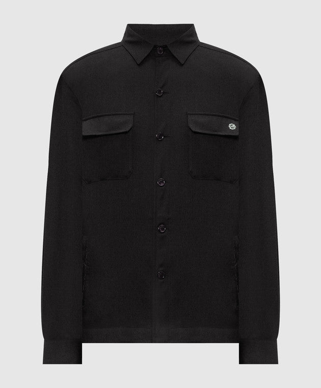 Black shirt jacket with a collar, button front, two chest flap pockets, and two side pockets. Silver-toned emblem on right ch