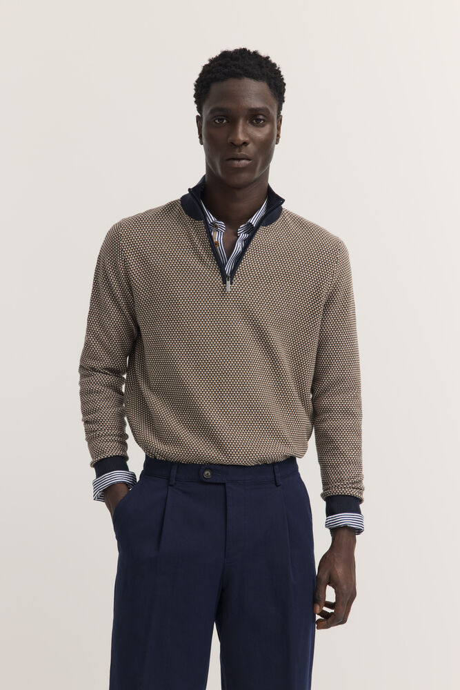 Brown and navy blue quarter-zip sweater with a small dot pattern, navy stand-up collar, and ribbed cuffs.