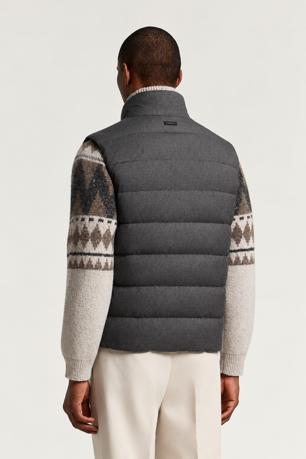 Carbon grey puffer vest with horizontal quilting on the back. Features a stand-up collar and a small black label on the colla