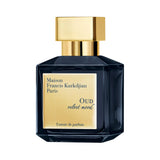 Dark blue faceted glass perfume bottle with a gold-toned rectangular cap and a gold-toned label reading 'OUD velvet mood'.