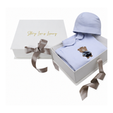 Light blue sleepsuit with collar and embroidered brown bear wearing a gold-toned crown, blue jacket, and black pants. Matchin