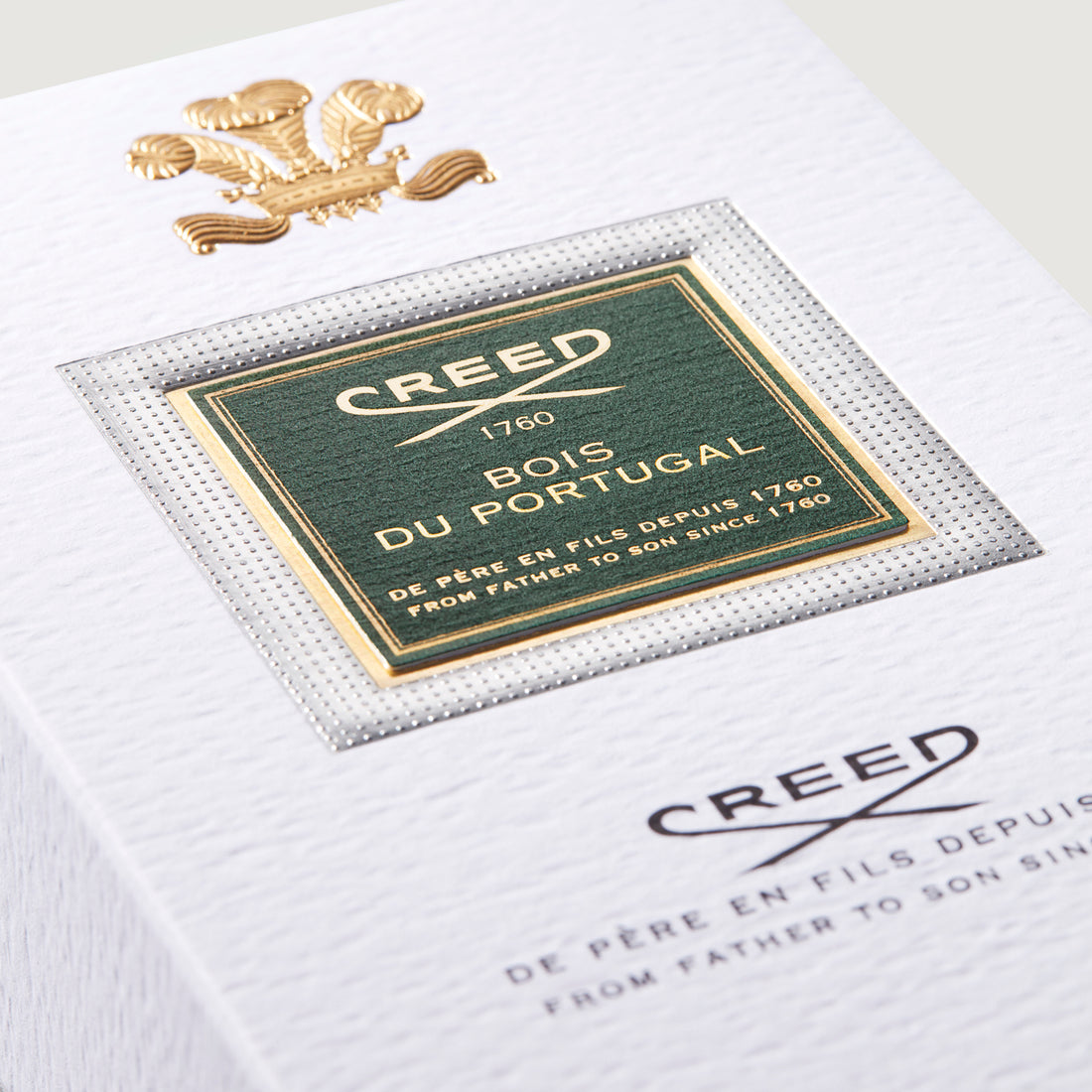 White box with a gold-toned crest. Features a green label with gold-toned border, "CREED BOIS DU PORTUGAL" text, on a silver-