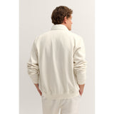 Ecru knitted jacket with a high collar, vertical ribbed texture, ribbed cuffs, and a ribbed hem, shown from the back.