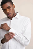 White casual shirt with a pointed collar, long sleeves, and buttoned cuffs. Features light-colored buttons.