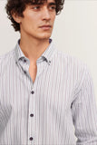 Men's long-sleeve casual shirt, white with thin dark grey/brownish-purple vertical stripes, button-down collar, dark buttons.