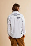 White long-sleeved shirt with 'PLAYER 03 CAPTAIN' and 'ARGENTINA' text on the back. Rounded hem, buttoned cuffs.