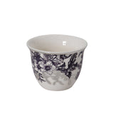 Close-up of a handleless ceramic gawa cup with intricate purple and grey botanical designs.